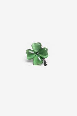 Zielony pin do marynarki w kształcie koniczyny.